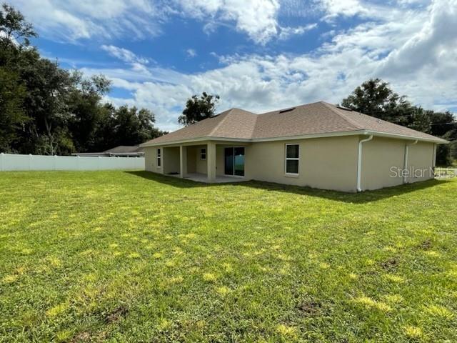 back of property featuring a lawn