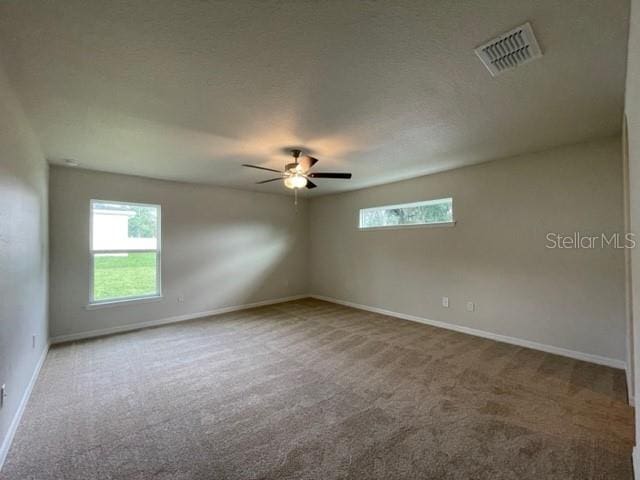 carpeted spare room with ceiling fan