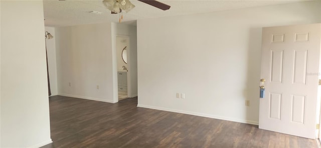 empty room with a textured ceiling, ceiling fan, and dark wood-type flooring