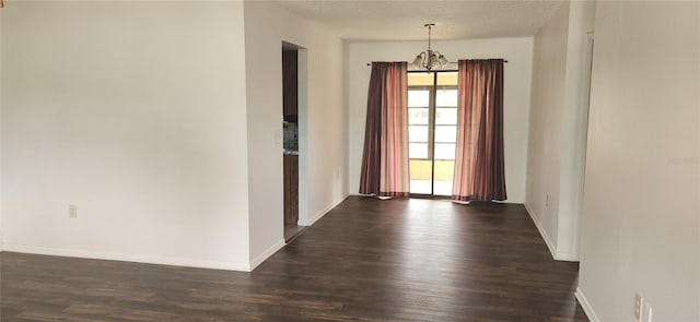 interior space featuring dark hardwood / wood-style flooring, a textured ceiling, and an inviting chandelier