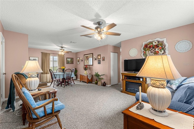 living room featuring a textured ceiling, carpet flooring, and ceiling fan