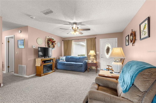 carpeted living room featuring a textured ceiling and ceiling fan