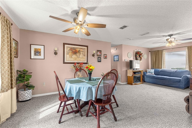 carpeted dining room featuring a textured ceiling and ceiling fan