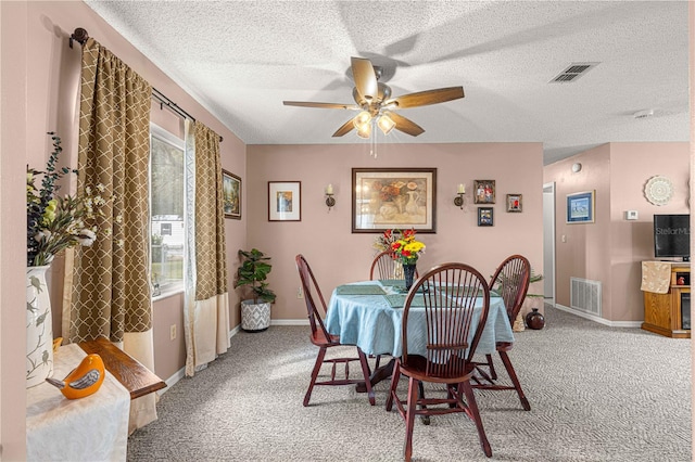 dining area with ceiling fan, a textured ceiling, and carpet floors