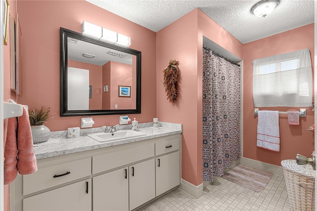 bathroom featuring vanity, a textured ceiling, curtained shower, and tile patterned floors