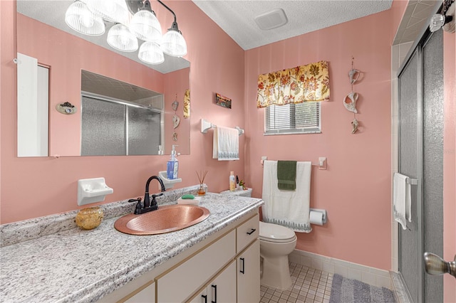 bathroom featuring a shower with door, a textured ceiling, toilet, vanity, and tile patterned flooring