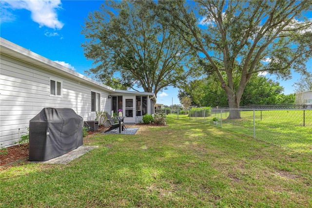 view of yard featuring a patio, central AC, and a sunroom