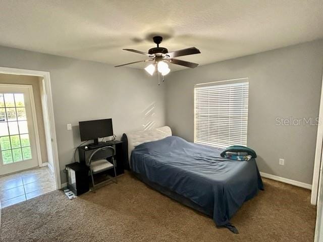 bedroom with ceiling fan and dark colored carpet