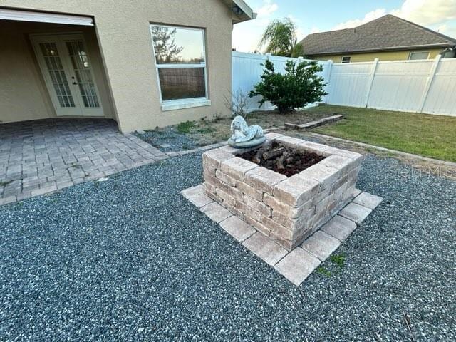 view of yard featuring french doors, a patio, and an outdoor fire pit