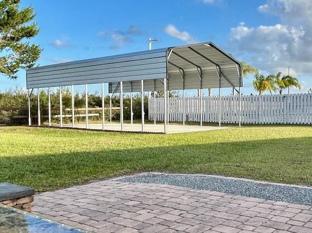 view of parking / parking lot featuring a lawn and a carport