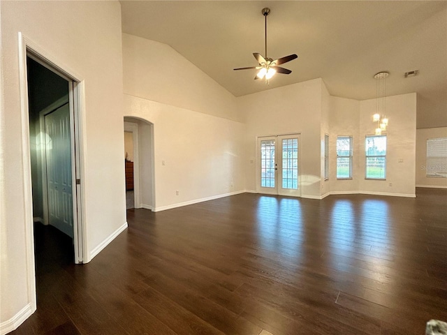 unfurnished living room with french doors, ceiling fan with notable chandelier, dark hardwood / wood-style floors, and high vaulted ceiling