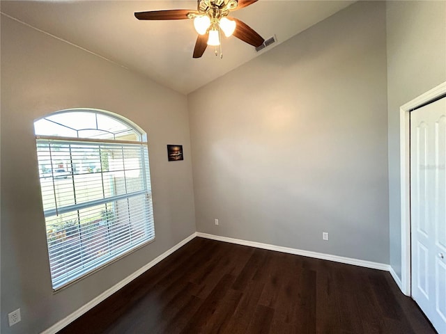 empty room with ceiling fan, lofted ceiling, and dark wood-type flooring