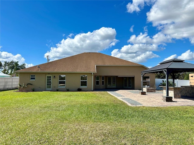 back of property with a gazebo, a lawn, and a patio