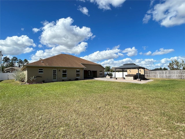 rear view of property with a gazebo and a lawn