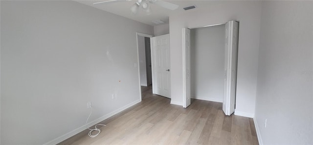 unfurnished bedroom with light wood-type flooring, ceiling fan, and a closet