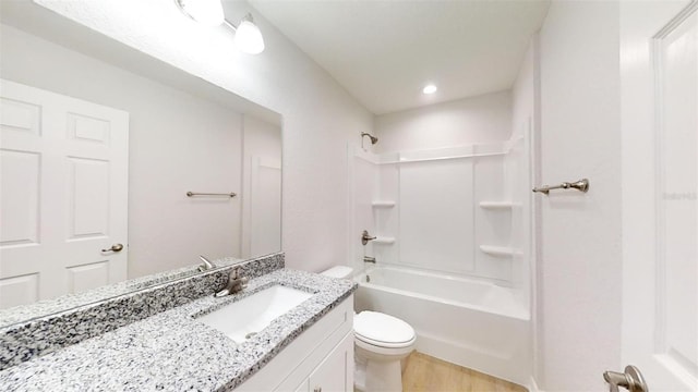 full bathroom featuring vanity, hardwood / wood-style flooring, bathtub / shower combination, and toilet