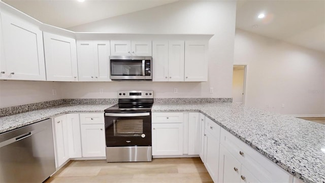 kitchen featuring white cabinetry, vaulted ceiling, and appliances with stainless steel finishes