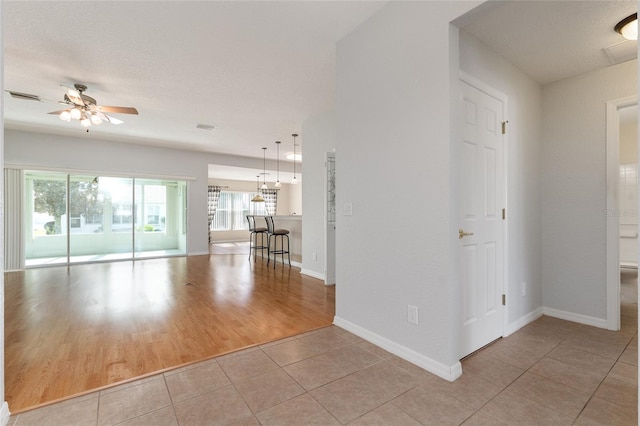 spare room featuring light hardwood / wood-style floors, a textured ceiling, and ceiling fan