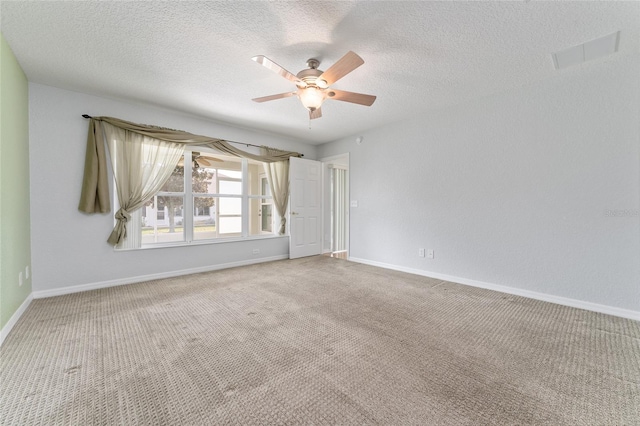 spare room featuring a textured ceiling, carpet, and ceiling fan