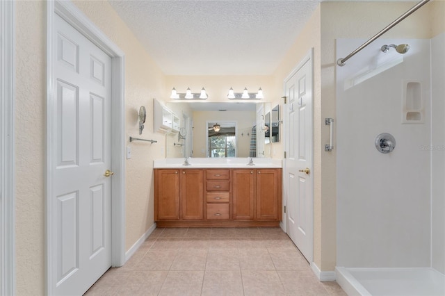 bathroom featuring vanity, tile patterned flooring, a textured ceiling, and walk in shower