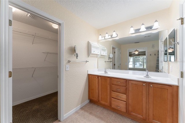 bathroom with vanity, a textured ceiling, tile patterned floors, and ceiling fan