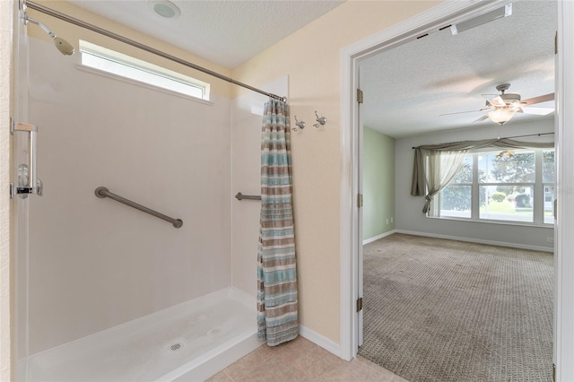 bathroom featuring ceiling fan, a textured ceiling, tile patterned flooring, and a shower with shower curtain