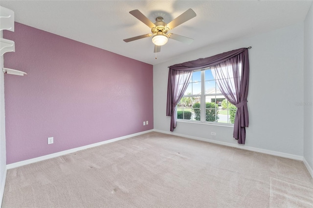 unfurnished room with light colored carpet and ceiling fan