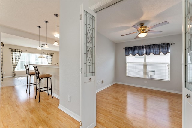 interior space featuring a textured ceiling, light wood-type flooring, and ceiling fan