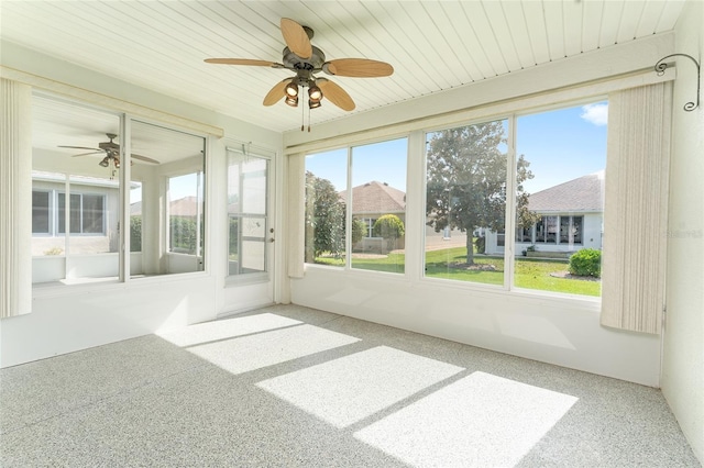 unfurnished sunroom featuring a wealth of natural light and ceiling fan