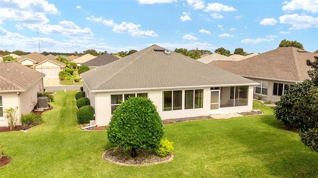 rear view of property featuring a yard, cooling unit, and a sunroom