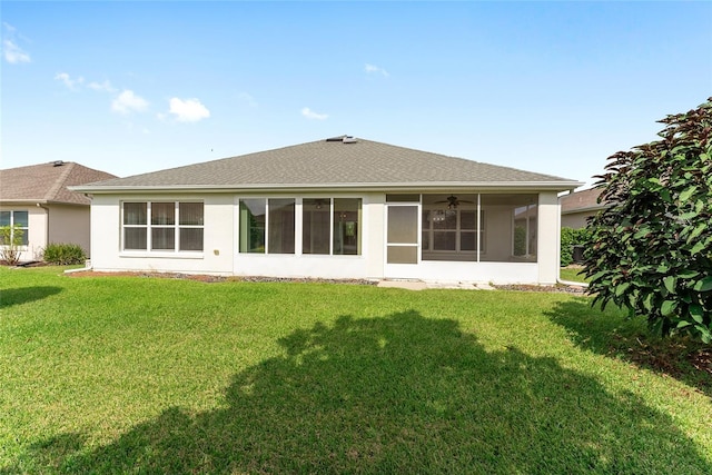 rear view of house featuring a yard, a sunroom, and ceiling fan