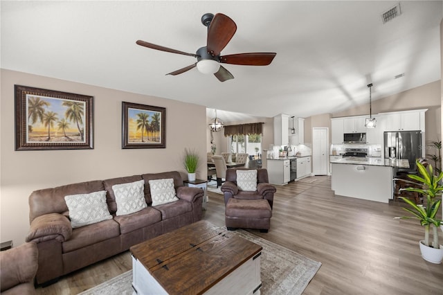 living room with hardwood / wood-style floors, ceiling fan, and lofted ceiling