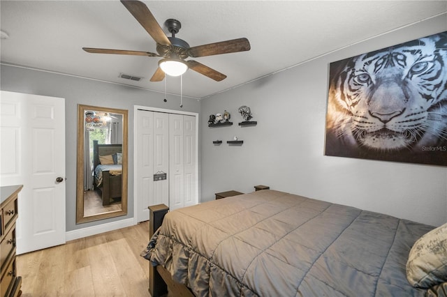 bedroom with ceiling fan, light wood-type flooring, and a closet