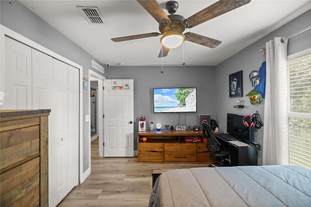 bedroom featuring ceiling fan, light wood-type flooring, and a closet