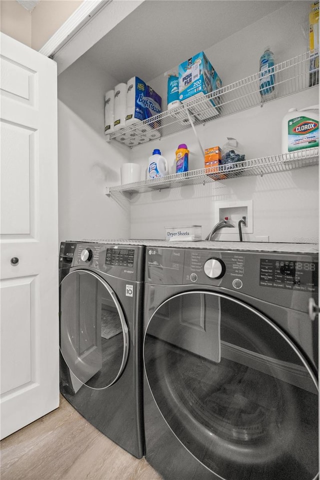 laundry room featuring independent washer and dryer and light wood-type flooring