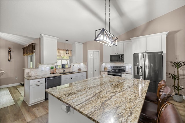 10291 SE 42nd Ter, Belleview, FL 34420 - kitchen with appliances with stainless steel finishes, vaulted ceiling, a sink, white cabinetry, and light stone counters