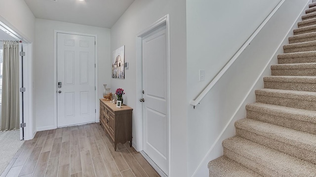 foyer featuring light wood finished floors and stairs