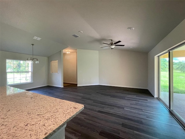 interior space with a textured ceiling, dark hardwood / wood-style flooring, ceiling fan with notable chandelier, and vaulted ceiling