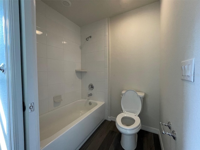 bathroom with hardwood / wood-style floors, tiled shower / bath combo, and toilet