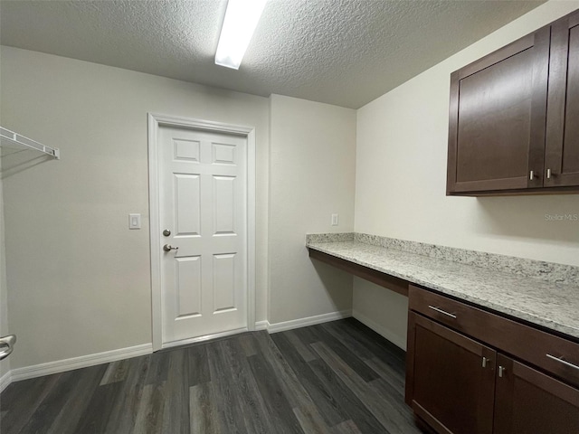 clothes washing area featuring a textured ceiling and dark hardwood / wood-style floors