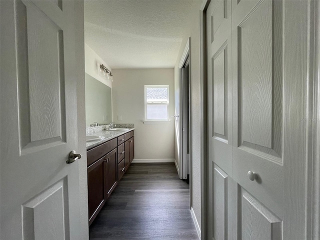 bathroom featuring hardwood / wood-style floors, vanity, and a textured ceiling