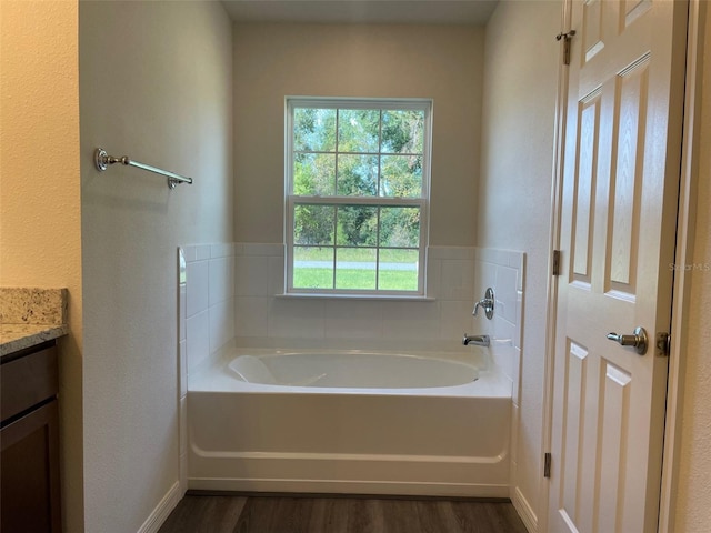 bathroom with hardwood / wood-style floors, vanity, and a bathing tub