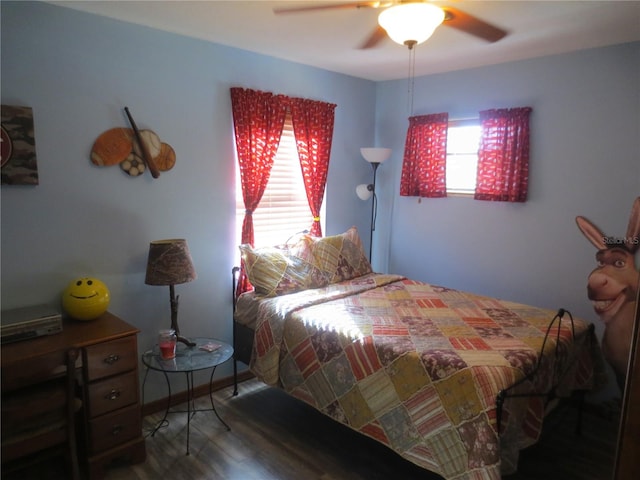 bedroom featuring multiple windows, dark hardwood / wood-style floors, and ceiling fan