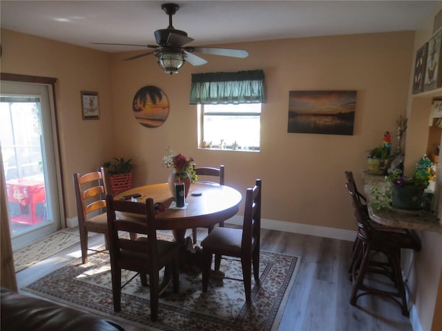 dining area with dark wood-type flooring and ceiling fan