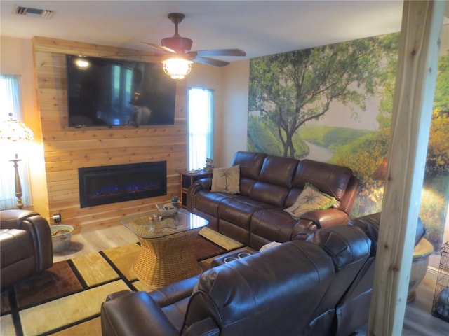 living room featuring ceiling fan, wood-type flooring, and plenty of natural light