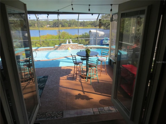 balcony with a water view, a patio, and a jacuzzi