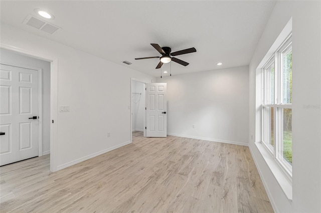 empty room featuring light hardwood / wood-style flooring, a healthy amount of sunlight, and ceiling fan