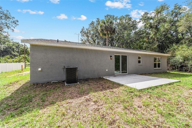 back of house with central AC unit, a patio, and a lawn