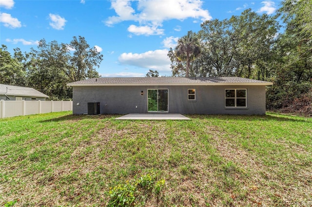 back of property with a patio area, central AC, and a lawn