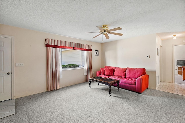 living room with a textured ceiling, carpet floors, and ceiling fan